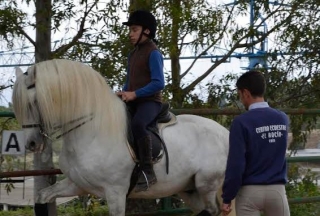 Instructor supervisando alumno y caballo